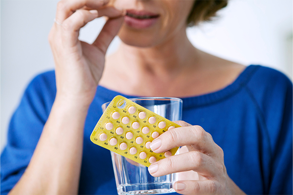 woman taking Hormone replacement therapy pills